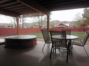 A covered patio with a hot tub, a round table, and four chairs. - Best location in Kanab! (Kanab)