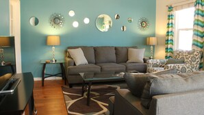 A living room with a sofa, coffee table, and lamps. There are decorative mirrors on the wall. - Best location in Kanab! (Kanab)