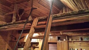 A rustic wooden interior with exposed beams and a lofted sleeping area. - Seven Springs Cabin - Fox Tail Chalet - Authentic, Pet Friendly Log Cabin Chalet (Champion)