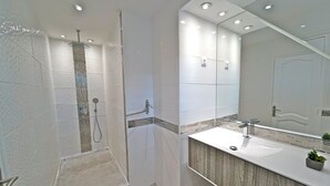 A modern bathroom with a walk-in shower, a large mirror, and a wooden vanity. - Grand Case beach (Grand Case)