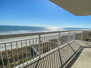 Un balcon avec vue sur la plage et l’océan.