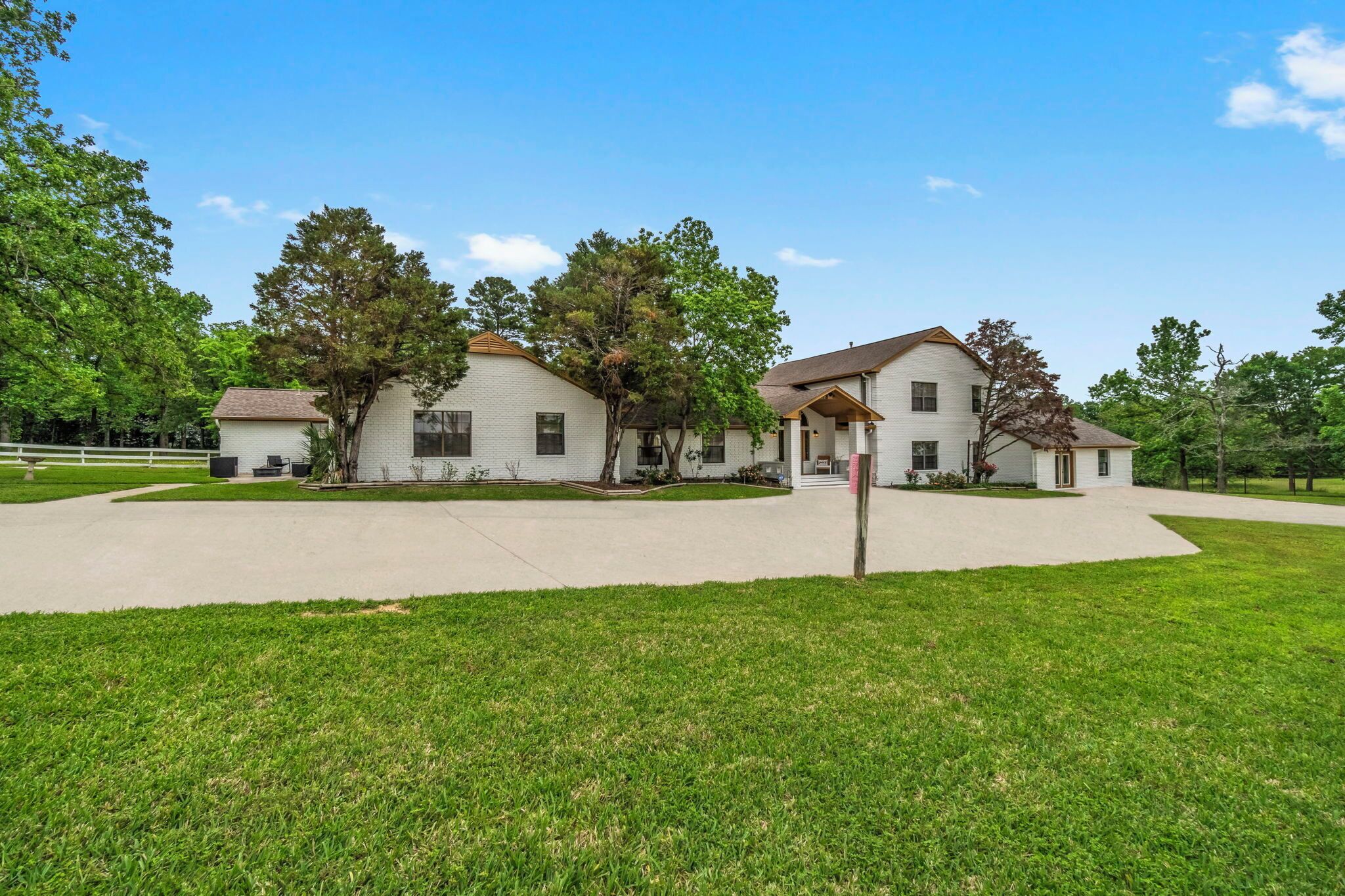 A two-story house with a driveway and a well-maintained lawn.