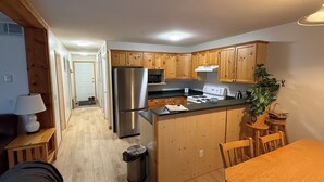 A compact kitchen with wooden cabinets, stainless steel appliances, and a central island.