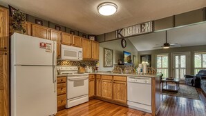 A kitchen with wooden cabinets, a refrigerator, microwave, stove, and a dishwasher. - River View Rental-Gameroom-Only 1 Mile Off Main Parkway Pigeon Forge-Hot Tub and more (PIGEON FORGE)