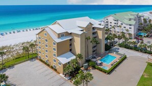 A hotel with a pool, beach view, and multiple buildings.