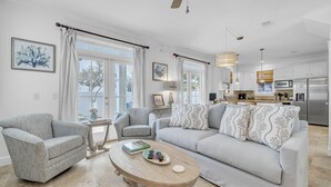 A living room with a sofa, two armchairs, a coffee table, and a kitchen in the background. - Sunset Seeker-Gulf Side 30A Villa w/ Community Pool,Pet Friendly! (Seacrest Beach)