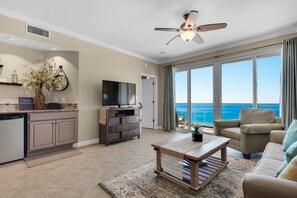 A living room with a television, a coffee table, and a sofa. There is a large window with a view of the ocean. - Beautiful Beachfront Property!2 Bdrm/2 Ba, Cov. Parking, Unit 802 (Destin)