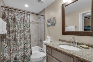 Een bad/douchecombinatie, een haardroger, handdoeken, zeep