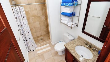 Ein Badezimmer mit Dusche, Toilette und Waschbecken.