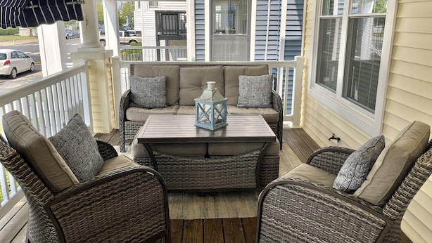 A covered porch with wicker furniture, a table, and a lantern. - Amazing Location! PRIME location on Wesley.  Includes Tags/Chairs/Umbrellas!  (Ocean City)