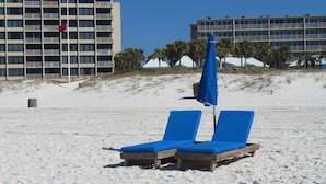 A beach with two blue lounge chairs and a blue umbrella. - Panama City Beachfront! 5STAR Dog Friendly! Vacation-Staycation or MicroCation! (Panama City Beach)