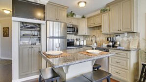 A kitchen with granite countertops, stainless steel appliances, and beige cabinetry. - On the Beach- cross over the dunes for sand between your toes (2221) (Galveston)