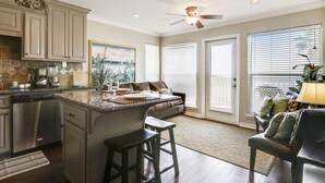 A spacious kitchen with a large island, built-in appliances, and a ceiling fan. - On the Beach- cross over the dunes for sand between your toes (2221) (Galveston)
