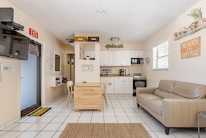 A compact living space with a kitchenette, a dining area, and a seating area.