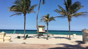 Ein Strand mit Palmen, einem Rettungsturm und einem strahlend blauen Himmel.