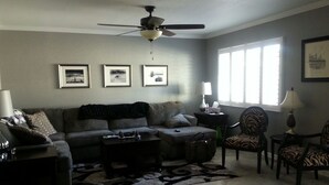 A living room with a ceiling fan, a sofa, a coffee table, a zebra-patterned chair, and a rug. - North Central Phoenix - Two Master Stes. 1500 Sf Newly Remodeled, Peaceful!! (Phoenix)