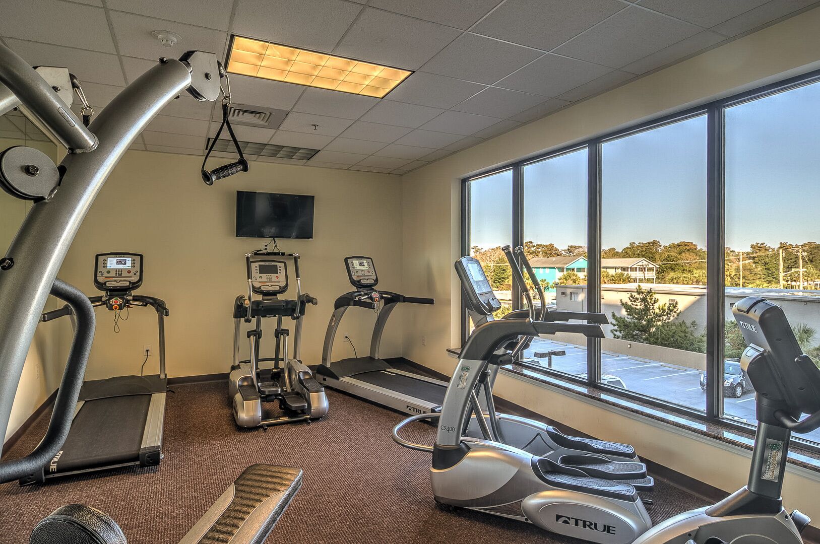 A gym with treadmills, elliptical machines, and a stationary bike.