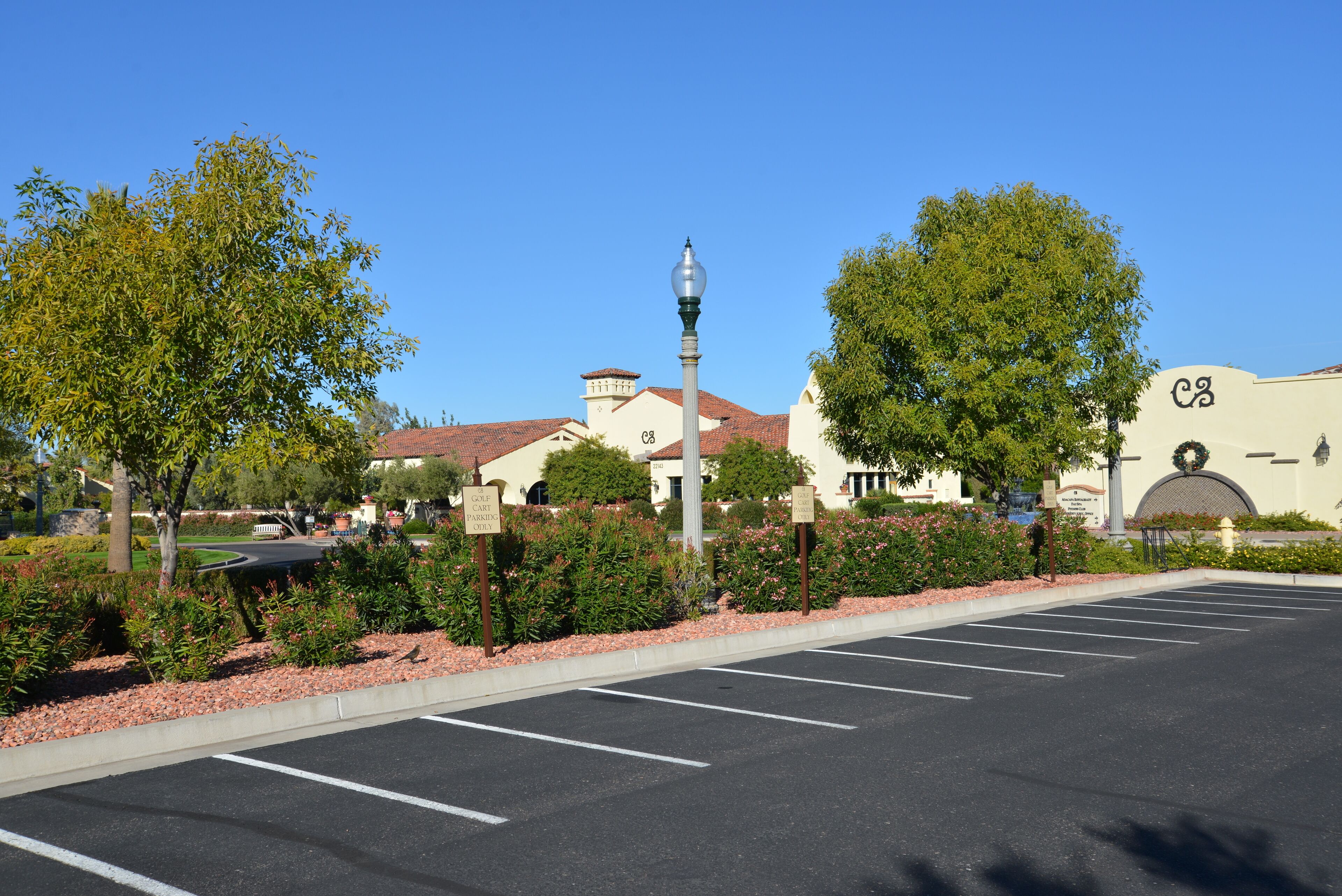 A parking lot with clear lines, a lamp post, and a building with a sign that reads "C3".