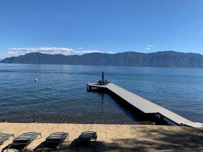 Vista sobre un llac amb un moll que s'endinsxa a l'aigua, envoltat de muntanyes.
