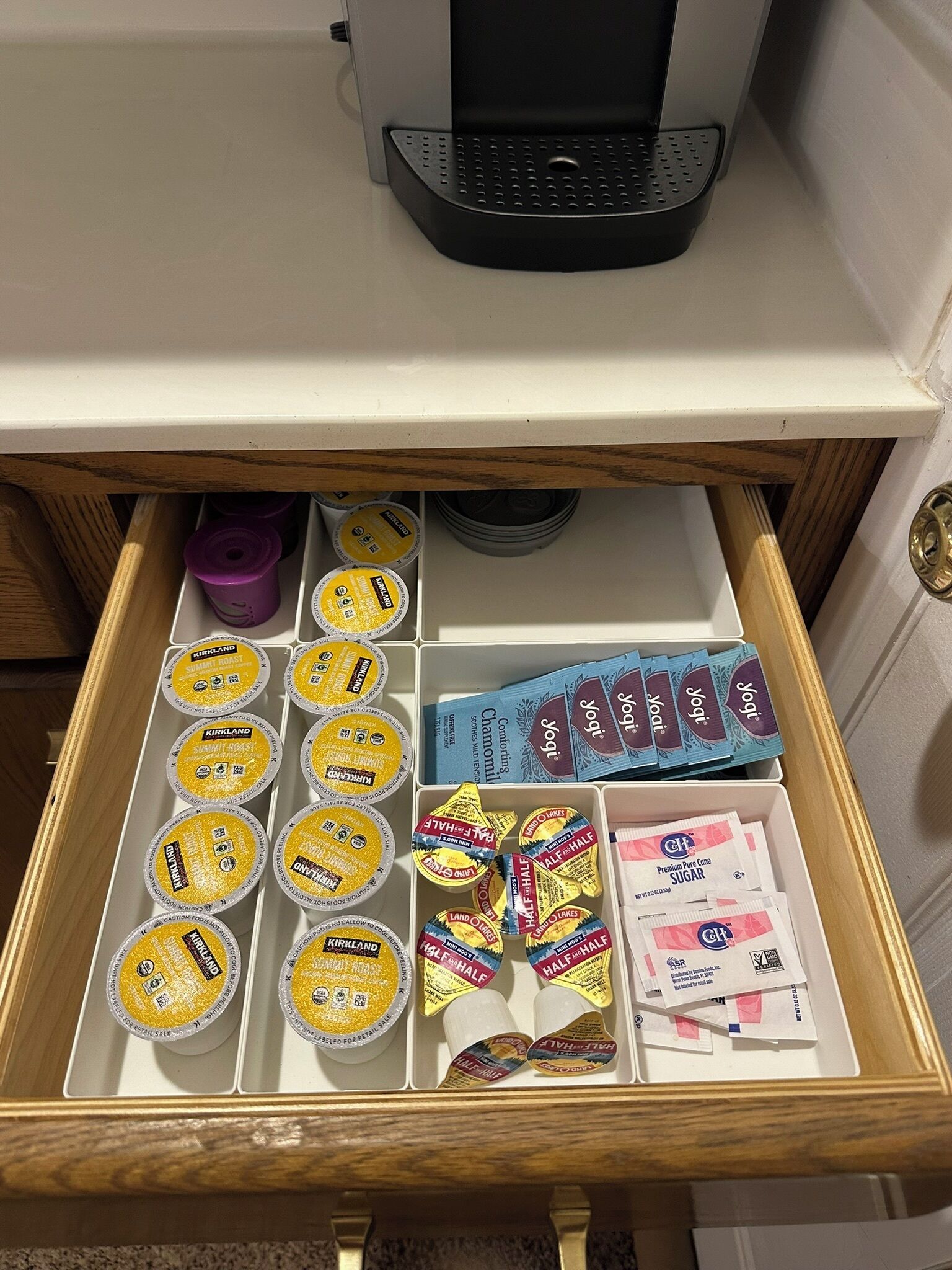 Un cajón con diversos productos alimenticios, como yogur, barras de chocolate y sobres de azúcar.