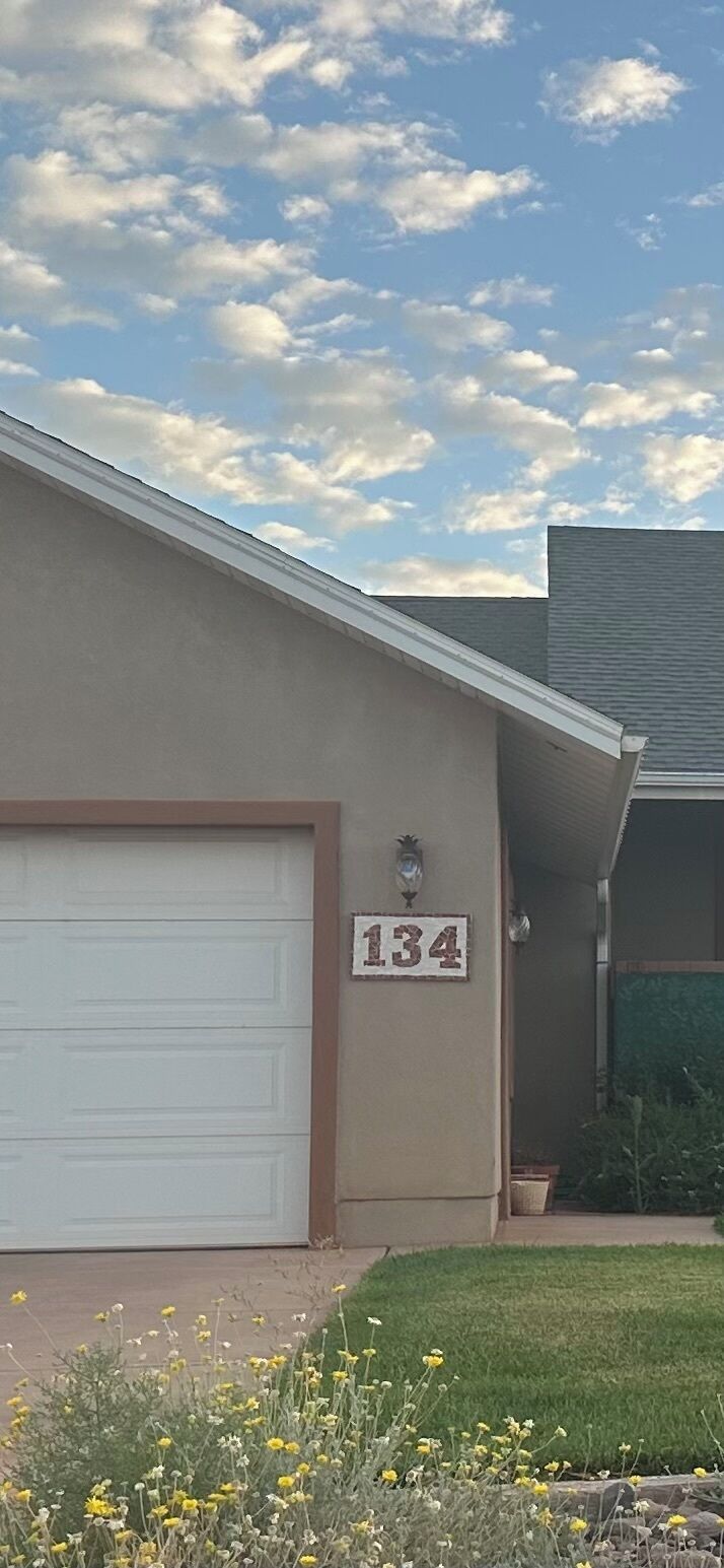 Una casa con puerta de garaje, buzón y un cartel con el número 134.