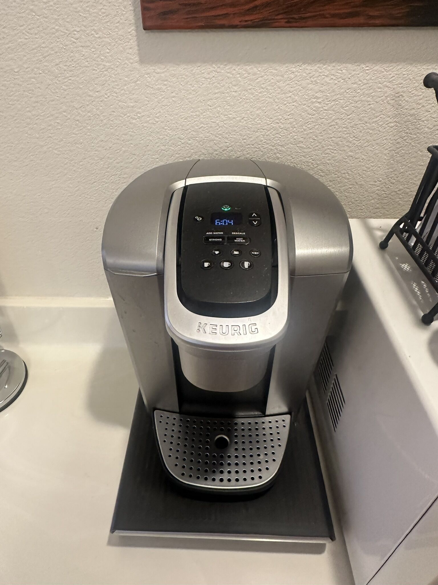 Una macchina da caffè Keurig su un piano di lavoro bianco.