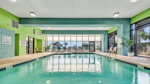 An indoor swimming pool with clear signage, a view of the outdoors, and a green and white color scheme. - Newly renovated, modern, ocean front, prime location!  Walk to everything! (Myrtle Beach)