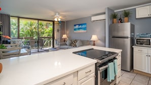 Una cocina moderna con una isla central, horno empotrado y refrigerador de acero inoxidable.