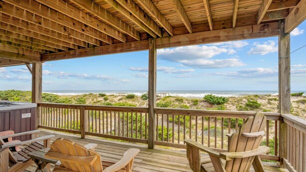 A wooden deck with two Adirondack chairs and a hot tub, overlooking a beach with dunes and ocean. - Oceanfront Home w/ Pool, Hot Tub, Game Room, Community Pool & Tennis/Pickleball (Avon)