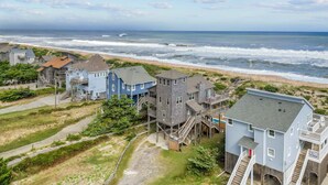 A coastal residential area with houses featuring multiple stories and balconies, situated close to the beach with visible waves. - Oceanfront Home w/ Pool, Hot Tub, Game Room, Community Pool & Tennis/Pickleball (Avon)