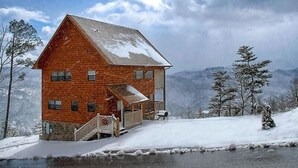 A log cabin with a porch and a small staircase leading to the entrance.