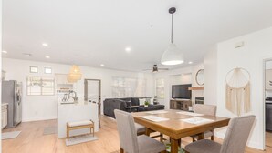 A modern apartment with a dining area, kitchen, living room, and a large TV. - Resort-like 2BR/2BA townhome in sunny Scottsdale near golf, hike, dine, shop etc (Scottsdale)