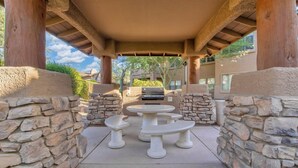 An outdoor patio with stone walls, a covered area, and a barbecue grill. - Resort-like 2BR/2BA townhome in sunny Scottsdale near golf, hike, dine, shop etc (Scottsdale)