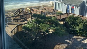 A beachfront property with a wooden deck and a view of the ocean.