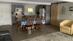 A compact living space with a dining area, kitchen, and a cozy seating area. - Peaceful Lakefront 3 bedroom Cottage On Quiet Forest Lake  (Gray)