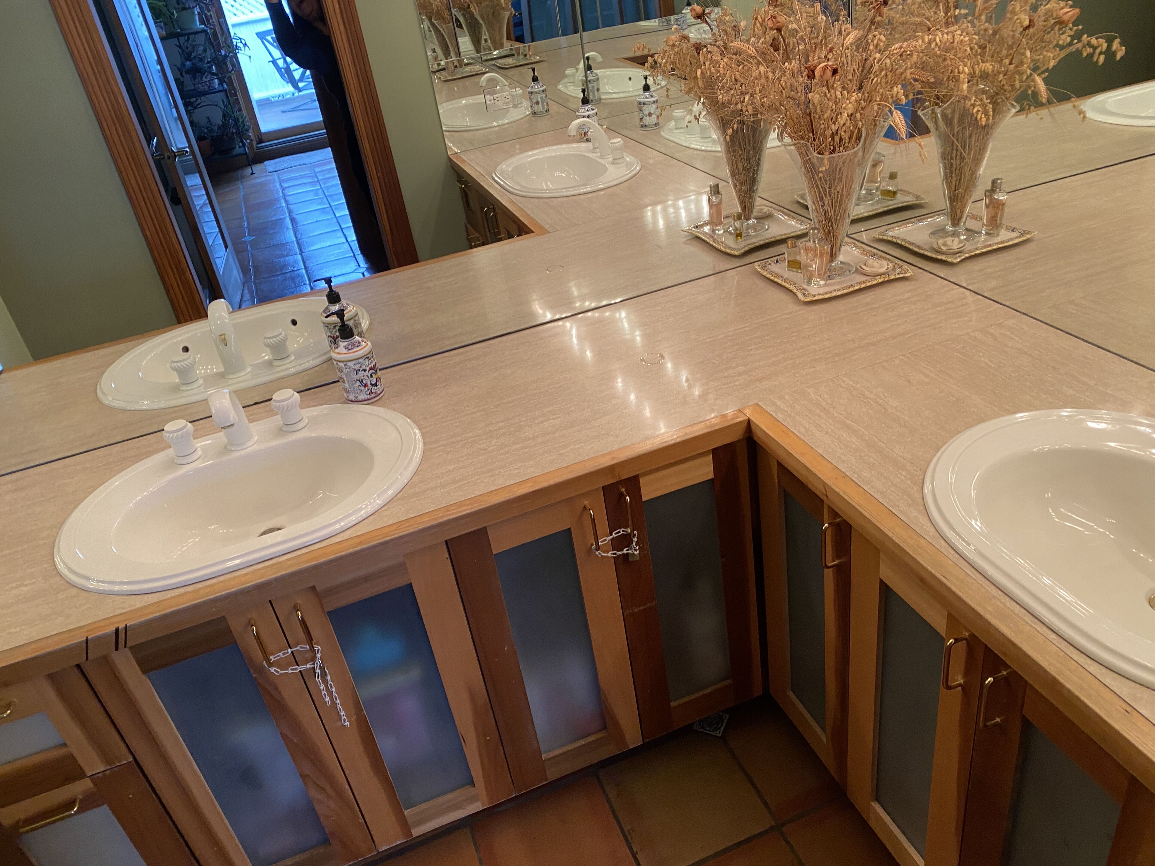 Ein Badezimmer mit zwei Waschbecken, Holzschränken und dekorativen Vasen.
