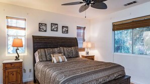A bedroom with a bed, two bedside tables, a ceiling fan, and three wall-mounted picture frames. - Inside Yosemite Park-Yosemite Spring Wonderland (Yosemite National Park)