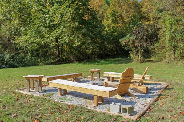 A picnic area with wooden benches and tables surrounded by trees.