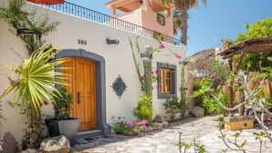 A Mediterranean-style building with a stone-paved entrance, a wooden door, and a balcony with a railing. - Beautiful and Cozy  Home in Loreto Bay, close from pool and wine bar (Loreto)