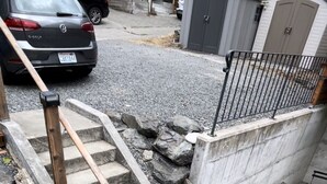 Ein Einfahrt mit einer Betonstufe, die zu einer Garage führt.