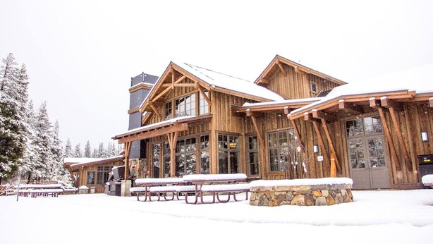 A wooden lodge with large windows and a stone foundation. - Winter wonderland perfect for multiple families- 3 master bedrooms! (Truckee)