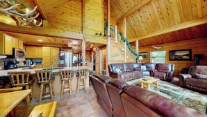 Ein Holzblockhaus-Interieur mit Küche, Essbereich und Wohnzimmer.