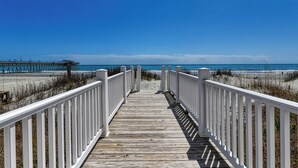 A wooden boardwalk leading to a beach with a pier in the background. - Against The Wind A, Oceanfront Home, Amazing Pier View, Duplex (Garden City Beach)