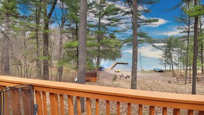 A deck overlooking a lake with a dock, surrounded by trees. - Executive Year Round Home ~ Minutes From  Minocqua (Arbor Vitae)