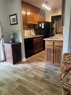A kitchen with wooden cabinets, a dishwasher, and a refrigerator.