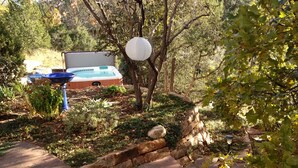 A garden with a hot tub, a stone wall, and a pathway. - Unsurpassed Night Skies And Fresh Mountain Air In A Traditional Village (Santa Fe)