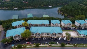 Een hotelcomplex bestaande uit meerdere gebouwen, elk met een blauw dak, gelegen nabij water.