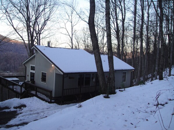 A cabin with a snow-covered roof, surrounded by trees and a mountain in the background. - Bella Vista~ 5 Star ~ Clean Cabin ~Hot Tub and Beautiful View ~Pets Allowed (Maggie Valley)
