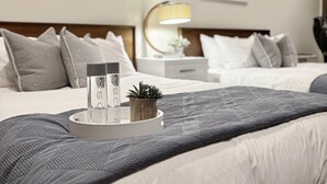 Ein Hotelzimmer mit einem großen Bett, einem Nachttisch mit Lampe und dekorativer Wandgestaltung.