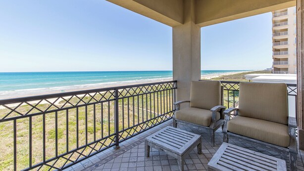 Un balcon avec vue sur la plage et l’océan.